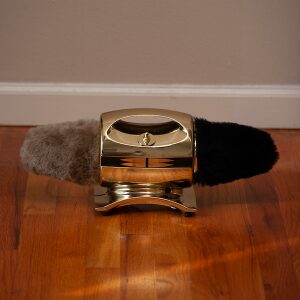 A gold shoe polishing machine with brushes on each side.