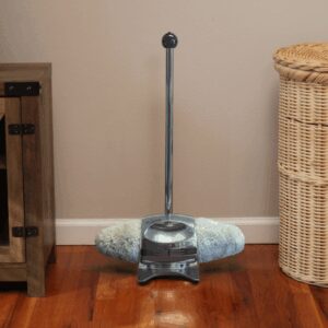 A modern vacuum cleaner on a hardwood floor near furniture.